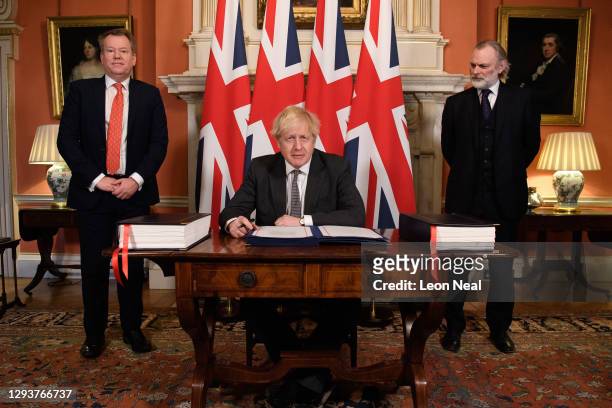 Prime Minister, Boris Johnson poses for photographs with UK chief negotiator David Frost and UK Ambassador to the EU Tim Barrow after signing the...