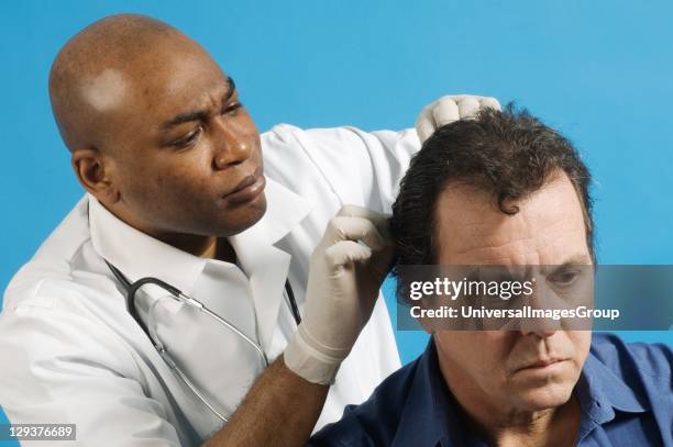 Male nurse examining hair of his patient for nits