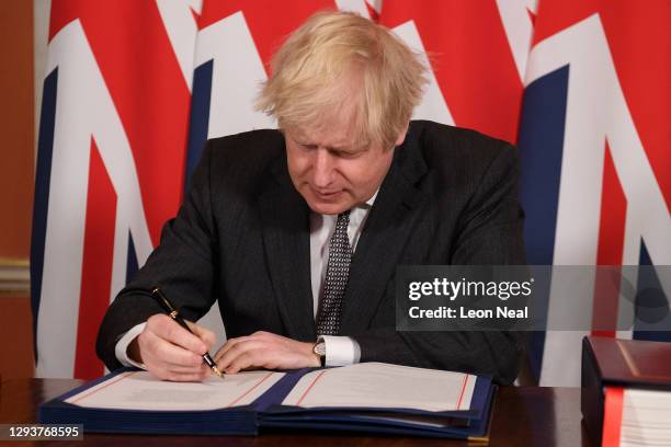 Prime Minister, Boris Johnson signs a page of the Brexit trade deal with the EU in number 10 Downing Street on December 30, 2020 in London, United...