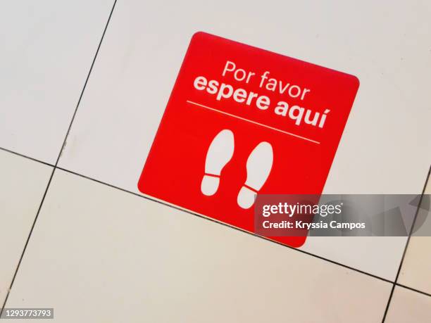 social distancing spanish language signage used during covid 19 - bodenmarkierung stock-fotos und bilder