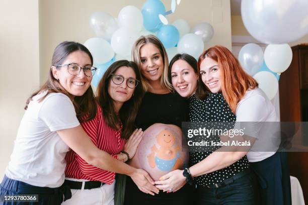 group of smiling friends with pregnant woman - babyshower stock-fotos und bilder
