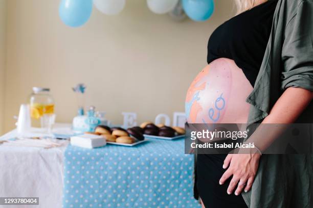 smiling young pregnant woman closeup with her belly painted - babyshower stockfoto's en -beelden