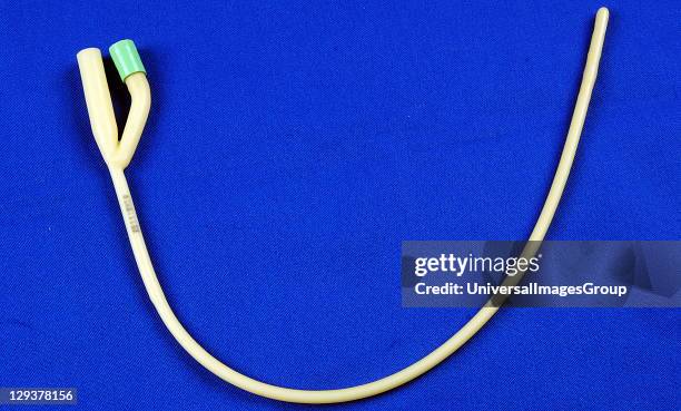 Paediatric foley catheter on blue table, This is often used to continually drain urine from the bladder following surgery when catheterization is...