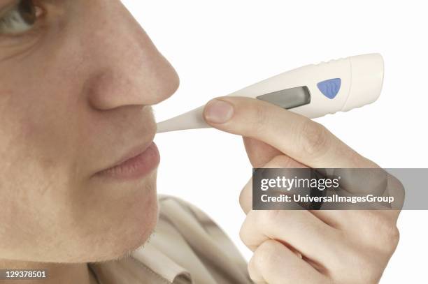 Man with digital thermometer in mouth