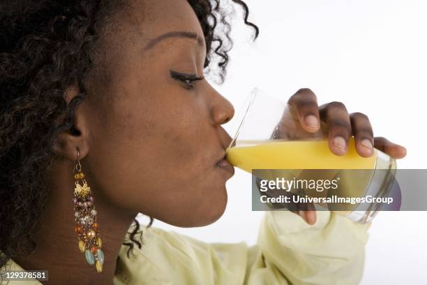 Profile of young woman drinking glass of orange juice