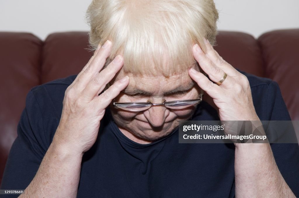 Senior woman holding her head in pain