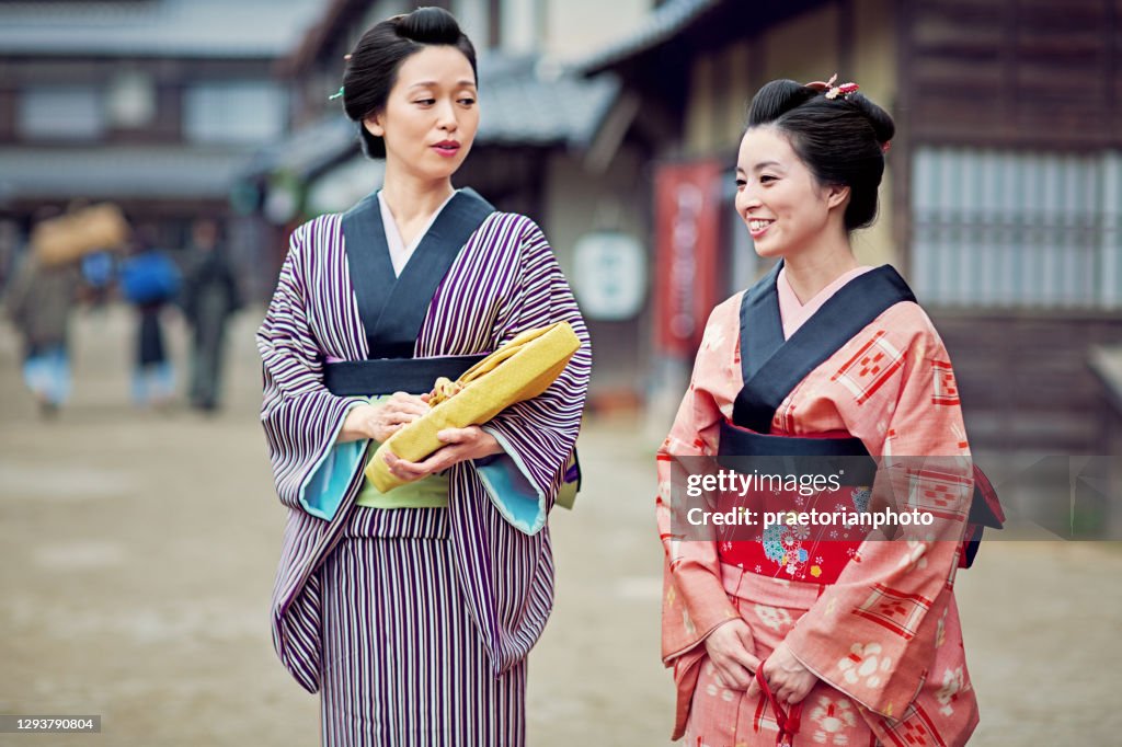 Japanische Frauen in traditionellen Kimonos sprechen auf der Straße