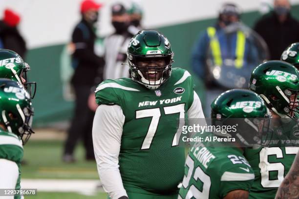Mekhi Becton of the New York Jets follows the action and has a laugh against the Cleveland Browns at MetLife Stadium on December 27, 2020 in East...