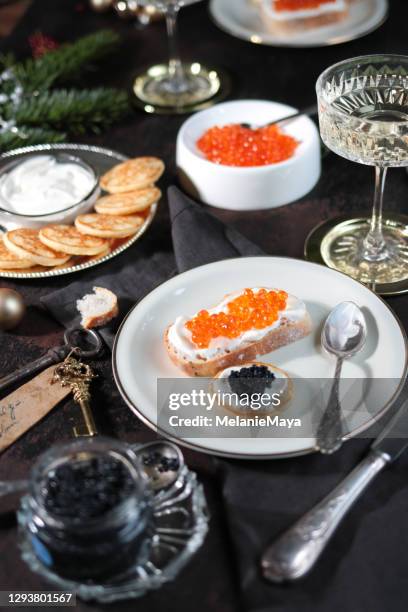 festive christmas table with caviar blinis and champagne - meal expense stock pictures, royalty-free photos & images