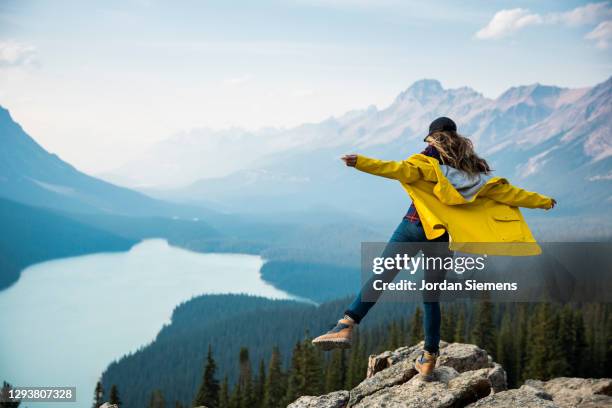 a woman standing on a rocky point overlooking peyto lake. - stå på ett ben bildbanksfoton och bilder
