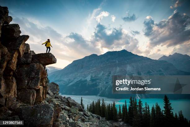 a woman standing on a rocky point overlooking peyto lake. - peyto lake stock pictures, royalty-free photos & images