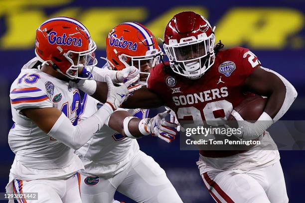 Running back Rhamondre Stevenson of the Oklahoma Sooners runs against defensive back Donovan Stiner of the Florida Gators during the first quarter at...