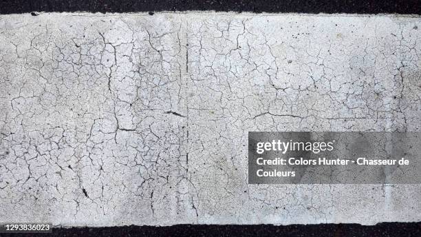 a weathered and worn white line of a pedestrian crossing - cracked stock pictures, royalty-free photos & images