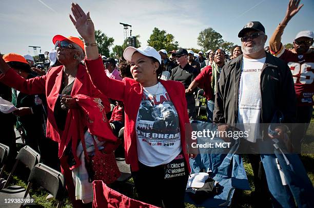 Sonya J. Bennetone-Patrick, center, and her husband, Ricky Patrick, right, of Wilmington, NC, and Patty P. Cherry, of Clinton, NC, dance and sing...