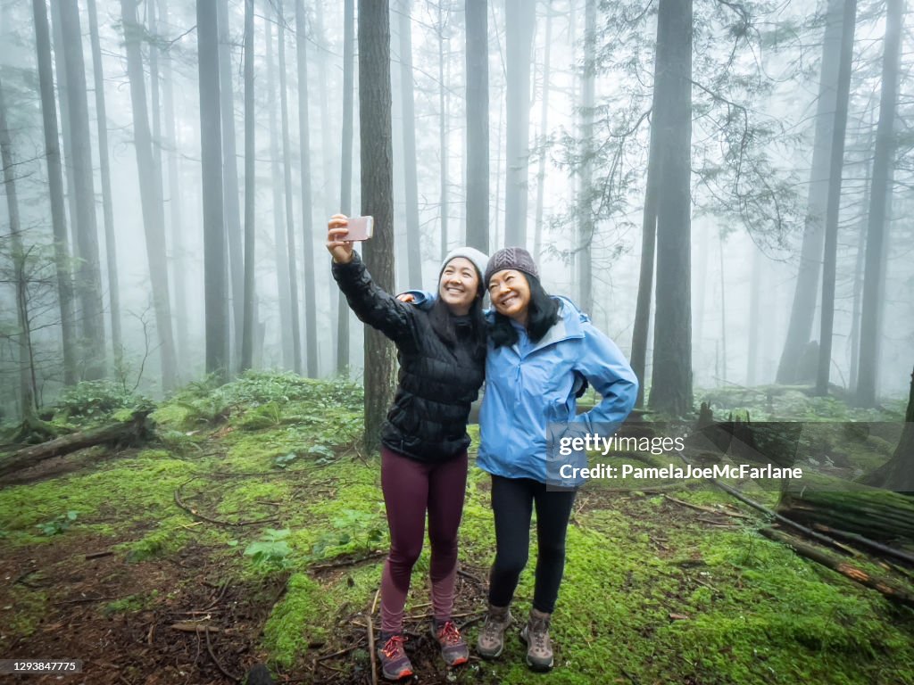 Eurasian Daughter Taking Selfie with Asian Mother in Misty Forest