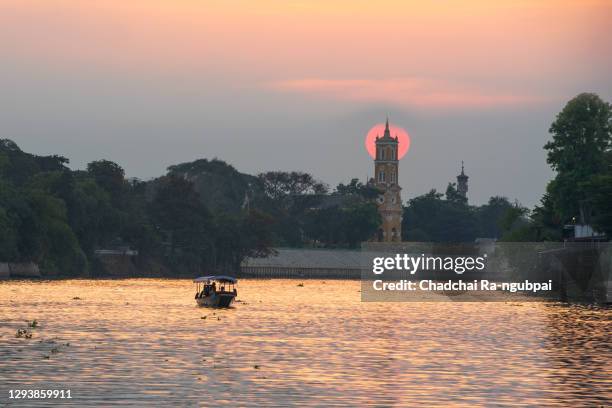 travel long-tailed boat at the chao phraya river and the church of joseph at sunset in ayutthaya, thailand. - god ra boat stock pictures, royalty-free photos & images