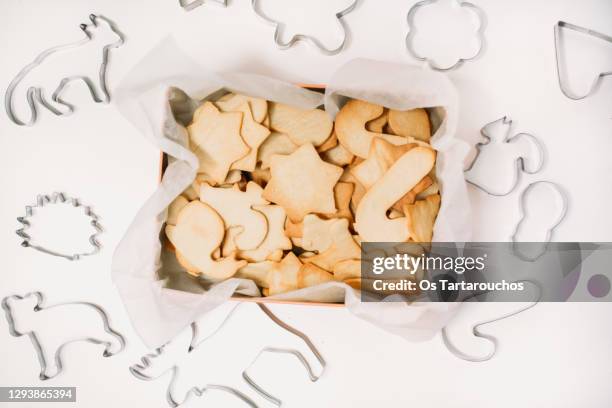 lay flat of a homemade cookies box surrounded by cookie cutters on a white background table - pastry cutter bildbanksfoton och bilder