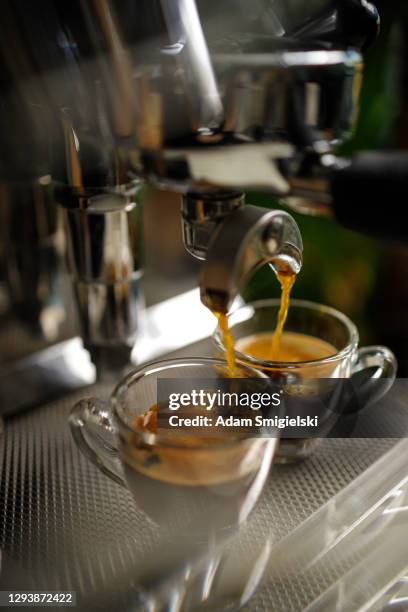 twee kopjes espresso wordt gegoten uit een espressomachine - color crema stockfoto's en -beelden