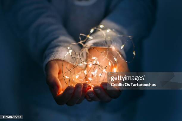christmas light on hands - snoerverlichting stockfoto's en -beelden
