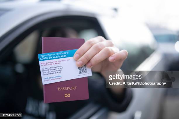 giving passport and certificate of covid-19 vaccination on border control. - immunization certificate stock pictures, royalty-free photos & images