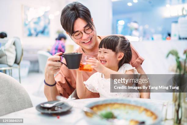 cheerful dad and daughter toasting while having meal in restaurant - asian family cafe stockfoto's en -beelden