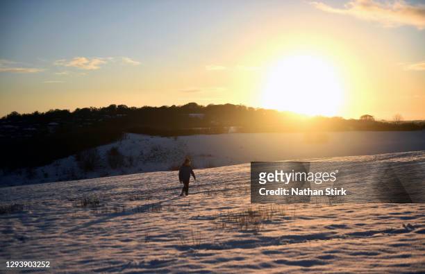 Man walks in the snow around Silverdale Country Park on December 31, 2020 in Newcastle-Under-Lyme, Staffordshire.