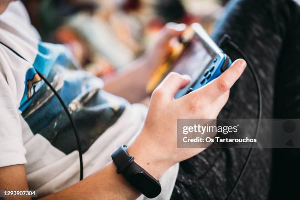 close up of boy hands with a smart watch playing videogames - gaming imagens e fotografias de stock