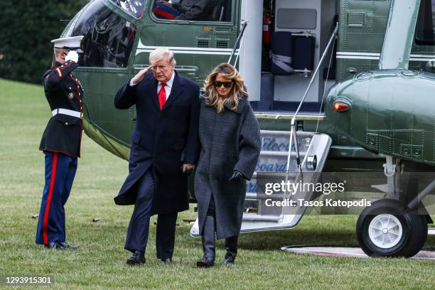 President Donald Trump and First Lady Melania Trump depart Marine One on the South Lawn of the White House on December 31, 2020 in Washington, DC....