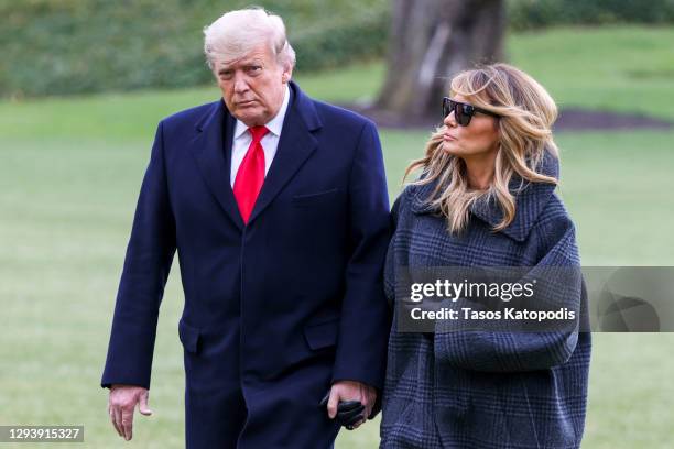 President Donald Trump and First Lady Melania Trump walk on the South Lawn while returning to the White House on December 31, 2020 in Washington, DC....