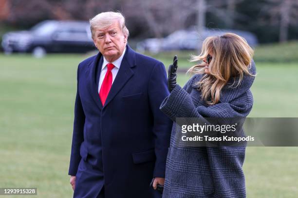 President Donald Trump and First Lady Melania Trump walk on the South Lawn while returning to the White House on December 31, 2020 in Washington, DC....