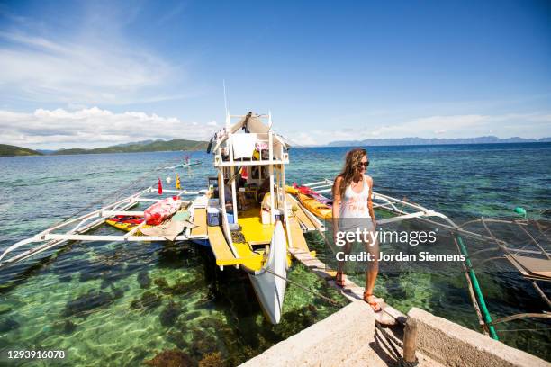 a woman walking off a bunk boat in the philippines while on a kayaking excursion. - el nido stock pictures, royalty-free photos & images