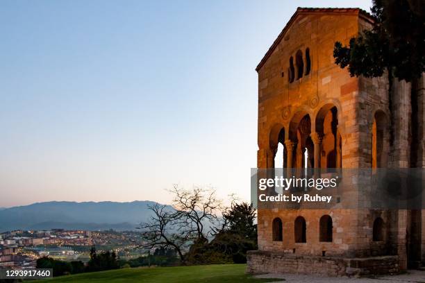 facade of santa maria del naranco at sunset with views of the city of oviedo in the background - oviedo stock pictures, royalty-free photos & images