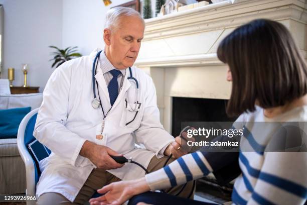 doctor taking blood pressure - california nursing homes stock pictures, royalty-free photos & images