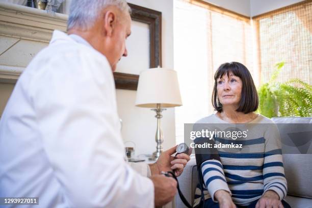 doctor taking blood pressure - california nursing homes stock pictures, royalty-free photos & images