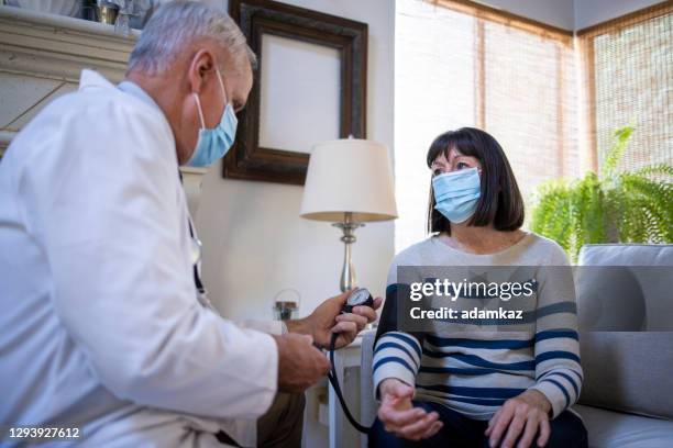 doctor taking blood pressure - california nursing homes stock pictures, royalty-free photos & images