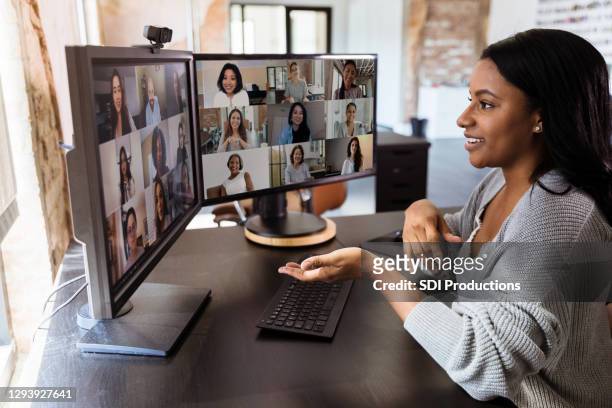 during covid-19, attractive woman gestures during virtual meeting with colleagues - multiracial group stock pictures, royalty-free photos & images