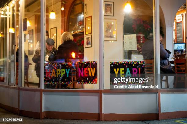 Happy New Year" sign is displayed near people dining at Il Violino on New Year's Eve on December 31, 2020 in New York City. New Year's Eve is...