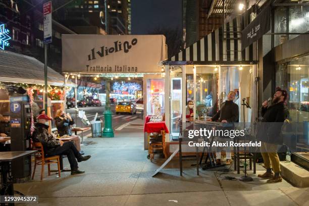 Musicians perform for customers dining at Il Violino on New Year's Eve on December 31, 2020 in New York City. New Year's Eve is traditionally one of...