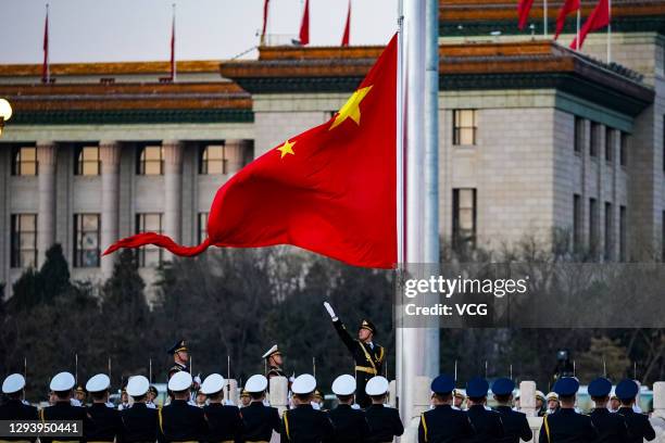 Soldiers of the People's Liberation Army honor guard perform the flag-raising ceremony at Tiananmen Square on New Year's Day on January 1, 2021 in...