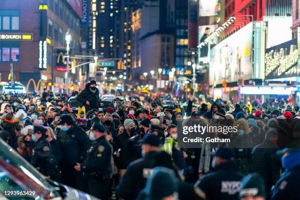 Crowds gather to watch the ball drop on New Year's Eve in Times Square on December 31, 2020 in New York City.