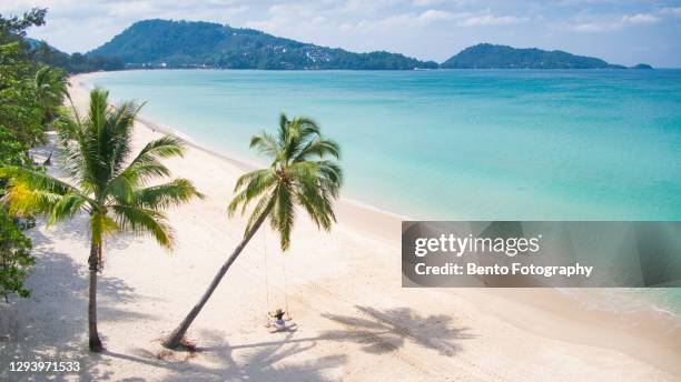 solo traveller play on coconut swing in patong beach, phuket, thailand. - phuket stock pictures, royalty-free photos & images