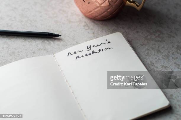 still life close-up of new year's resolution written on a note pad - new years resolutions stock-fotos und bilder