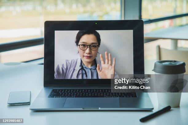 personal perspective shot of consulting asian doctors online using laptop from work - portatil en oficina subjetivo pantalla fotografías e imágenes de stock