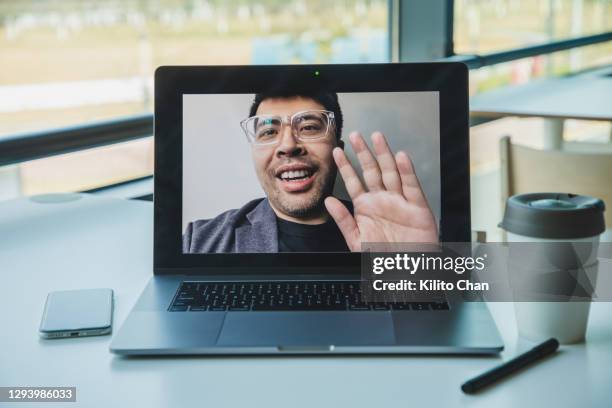 personal perspective shot of video calling an asian man using laptop - portatil en oficina subjetivo pantalla fotografías e imágenes de stock