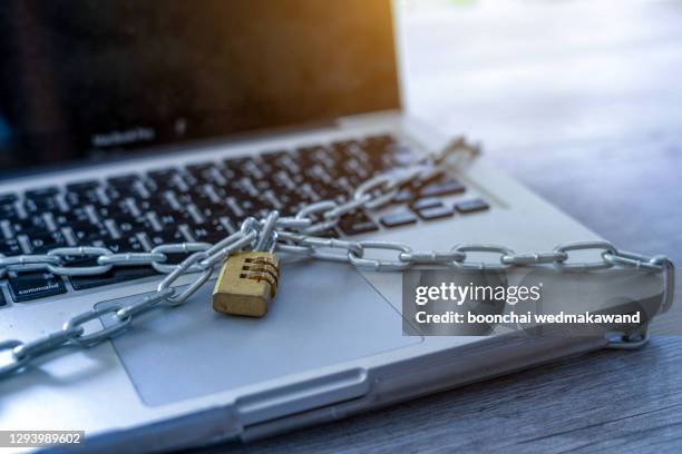 cyber safety concept, locked chain on laptop computer keyboard - lock sporting position - fotografias e filmes do acervo