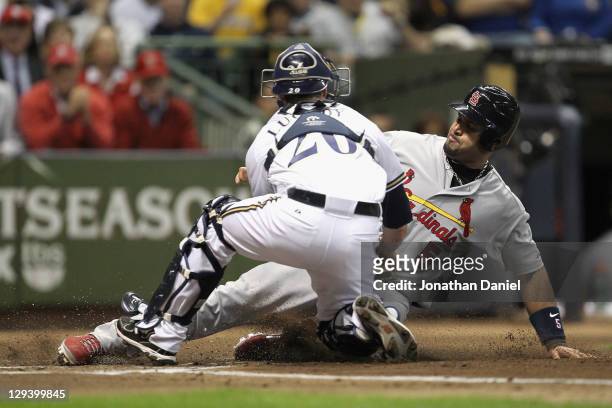 Albert Pujols of the St. Louis Cardinals is tagged out trying to score against Jonathan Lucroy of the Milwaukee Brewers in the top of the first...