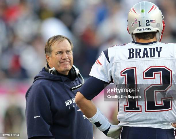 Coach Bill Belichick chats with Tom Brady of the New England Patriots during a review of a play against the Dallas Cowboys in the first half at...