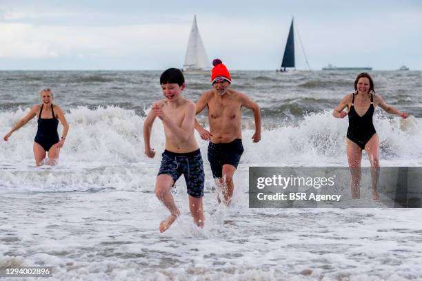 People are seen running into the water at Scheveningen Beach for an alternative New Years Dive on January 1, 2021 in Scheveningen, Netherlands. The...