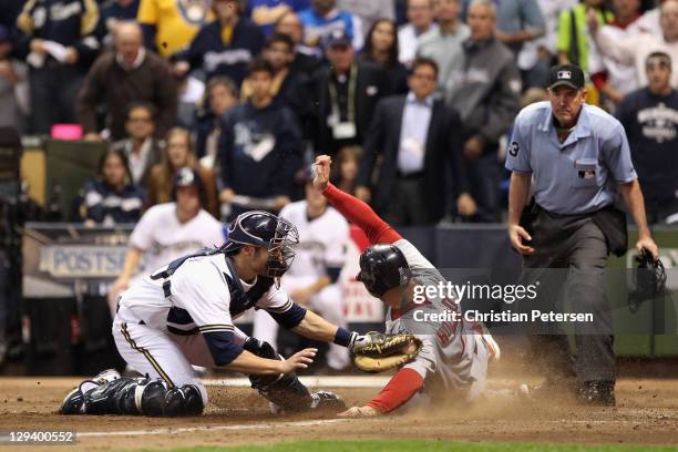 Matt Holliday of the St. Louis Cardinals scores on a sacrifice fly by Nick Punto in the top of the third inning against catcher Jonathan Lucroy of...