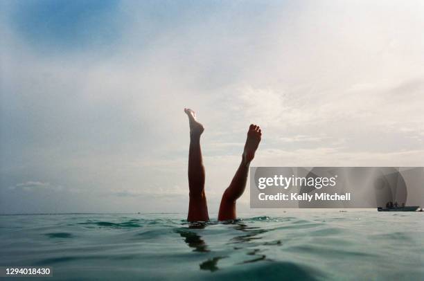 swimmer legs in the sea at sunset - piernas en el aire fotografías e imágenes de stock